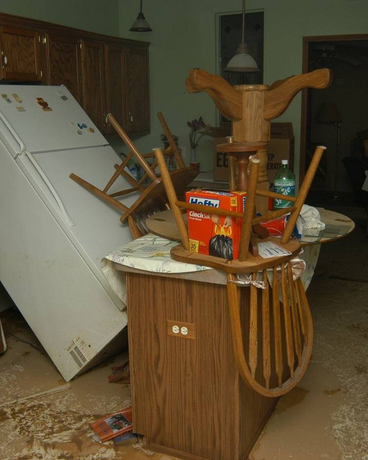 Kitchen damaged by floodwater with cabinets and drywall torn out