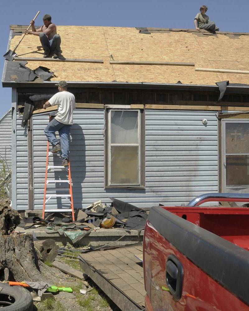 Workers clearing a storm-damaged roof